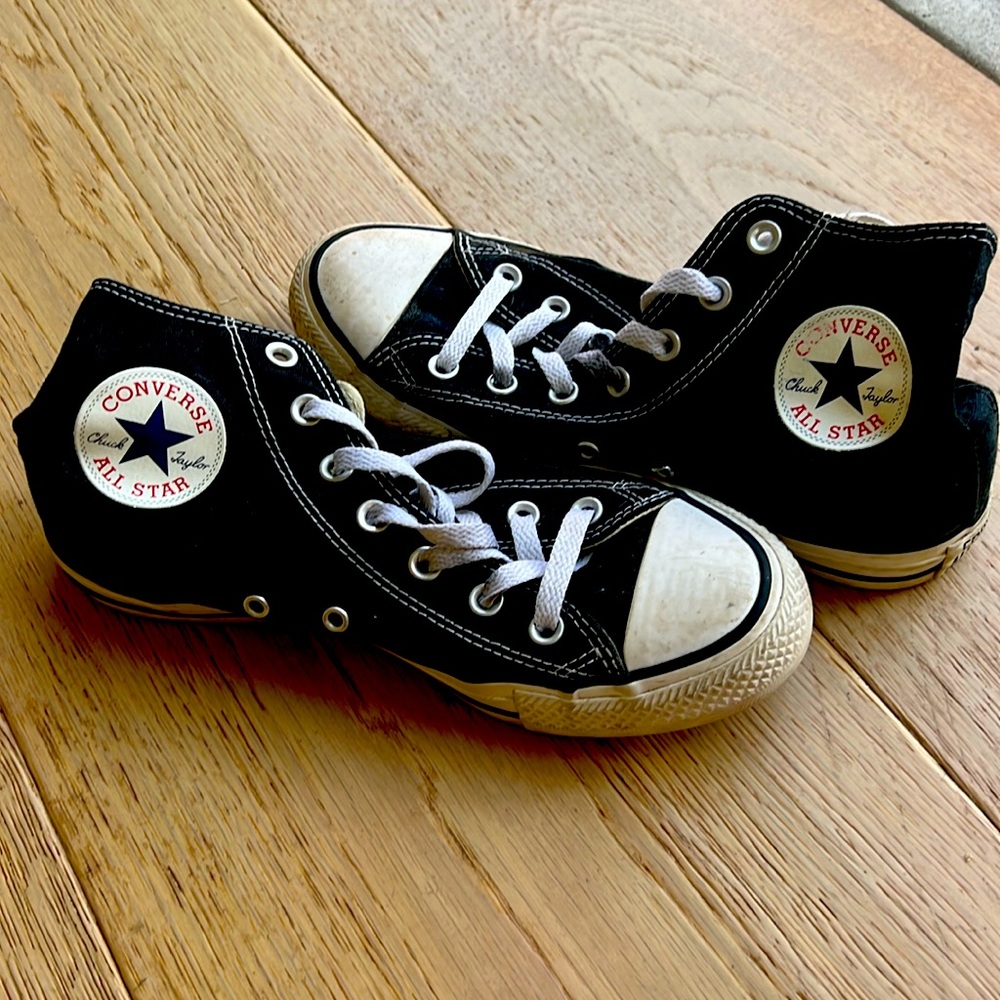 Black hightop Chuck Taylor All Star shoes.